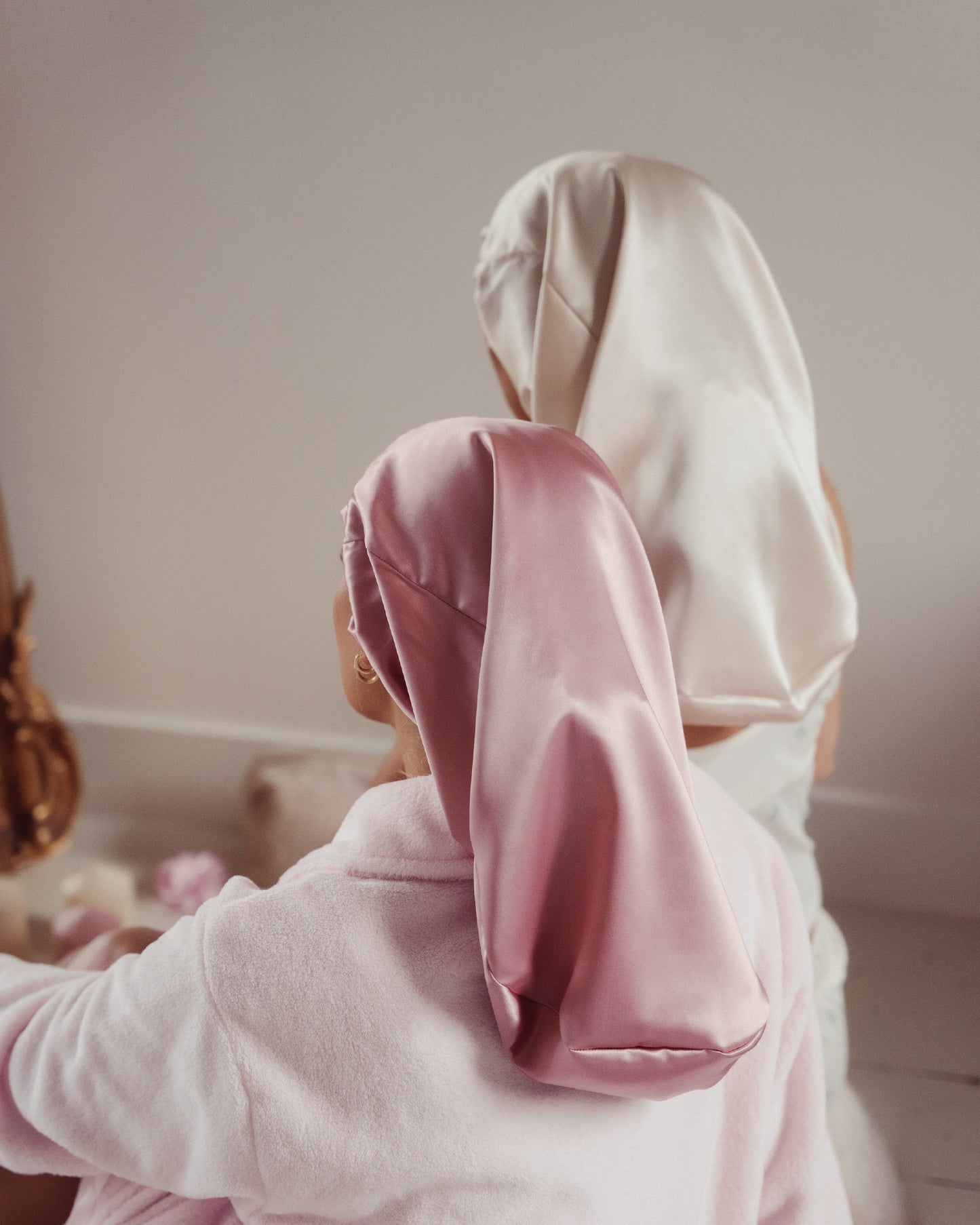 100% moerbei Zijden Bonnet voor lang haar in de kleur roze en creme op model. 