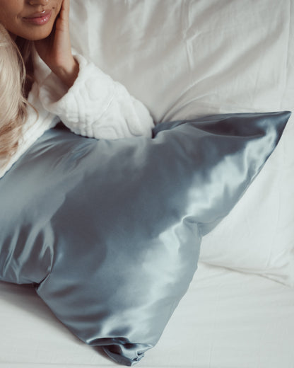 Luxe 100% moerbei zijden kussensloop van Silky Family in de kleur blauw op bed met model
